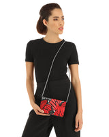 Woman holding a red Leather clutch bag with butterfly pattern and chain strap