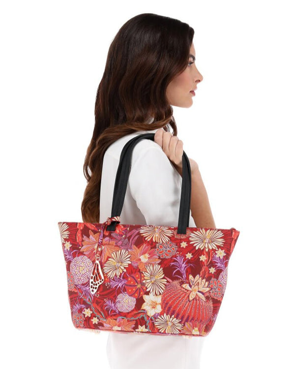 Woman holding a colorful floral tote bag on a white background
