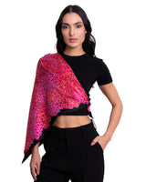 Woman wearing a black top and black pants with a colorful shawl draped over her shoulders