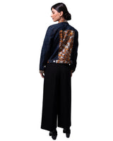Woman wearing a denim jacket with monarch butterfly pattern